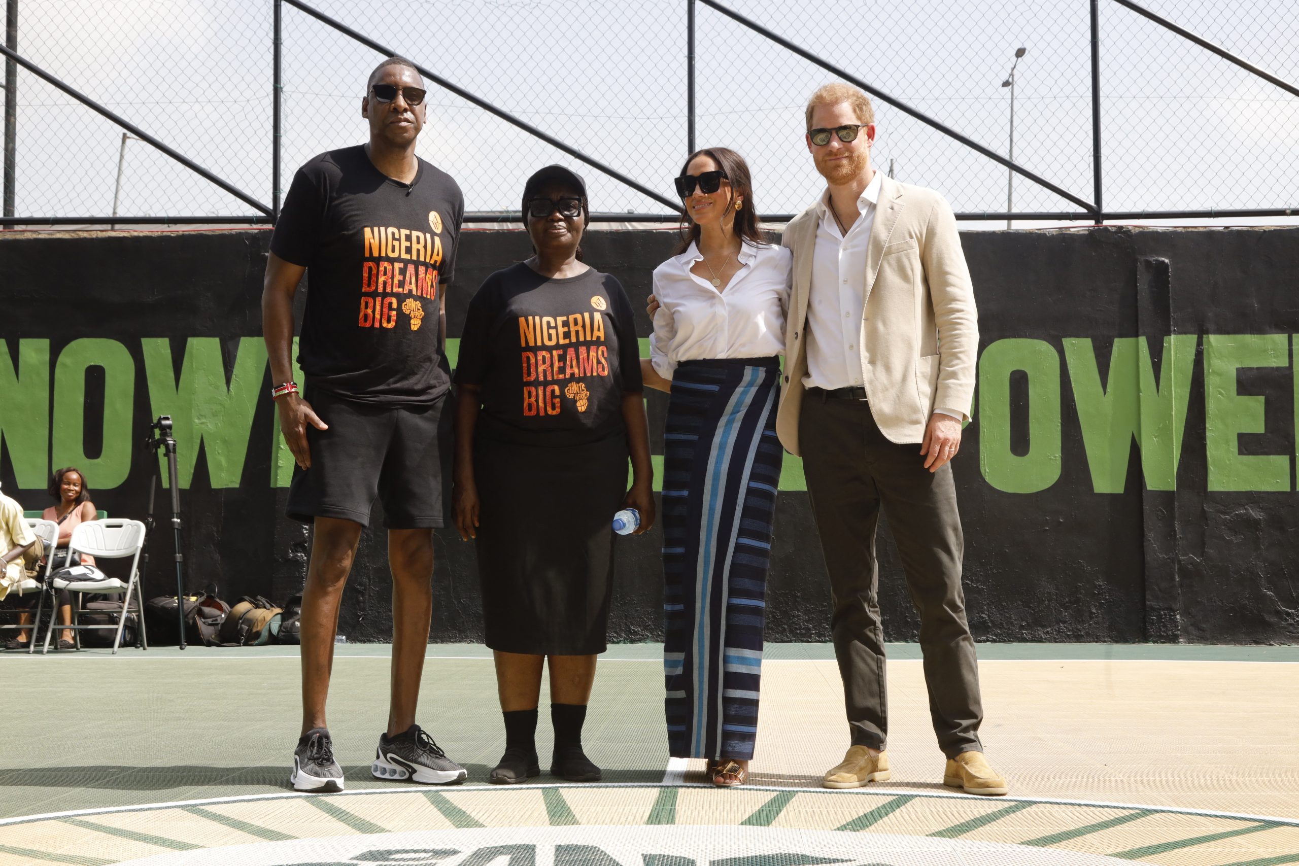 Toronto Raptors basketball team's President, Masai Ujiri (L) Principal of Ilupeju Grammar School, Josephine Egunyomi (2ndL), Britain's Meghan, Duchess of Sussex (2ndR) and Britain's Prince Harry (R), Duke of Sussex, pose for a photo during a basketball exhibition training match at Ilupeju Grammar School in Lagos on May 12, 2024 as they visit Nigeria as part of celebrations of Invictus Games anniversary. 