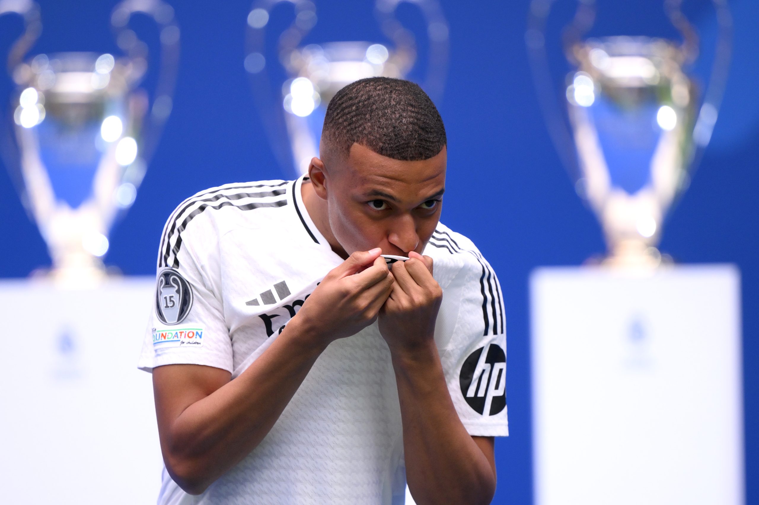 Real Madrid new signing, Kylian Mbappe kisses the Real Madrid badge as he is unveiled at Estadio Santiago Bernabeu on July 16, 2024 in Madrid, Spain.