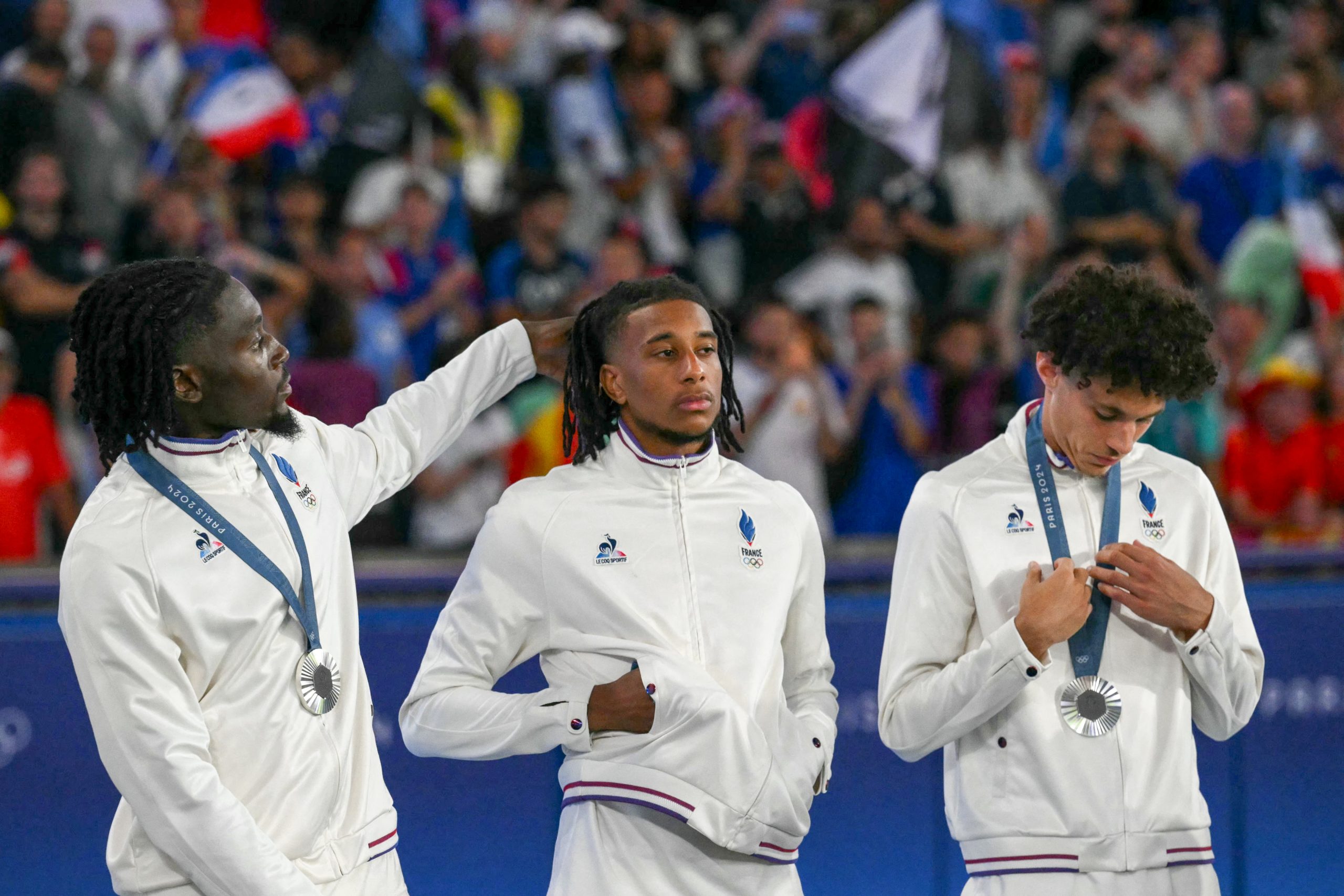 Silver medallists France's midfielder #06 Manu Kone, France's forward #07 Michael Olise and France's midfielder #08 Maghnes Akliouche pose on the podium after the men's final football match between France and Spain during the Paris 2024 Olympic Games at the Parc des Princes in Paris on August 9, 2024.